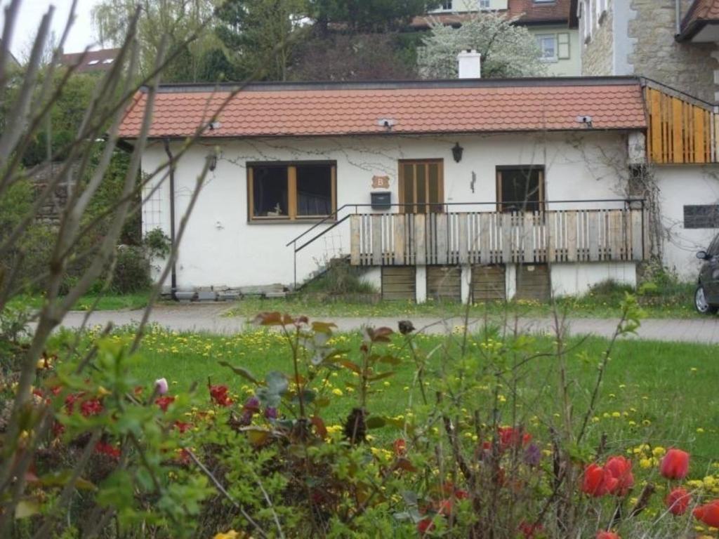 Casa blanca con balcón en un patio en Ferienwohnung mit Terrasse und Parkplatz - a78602 en Igersheim