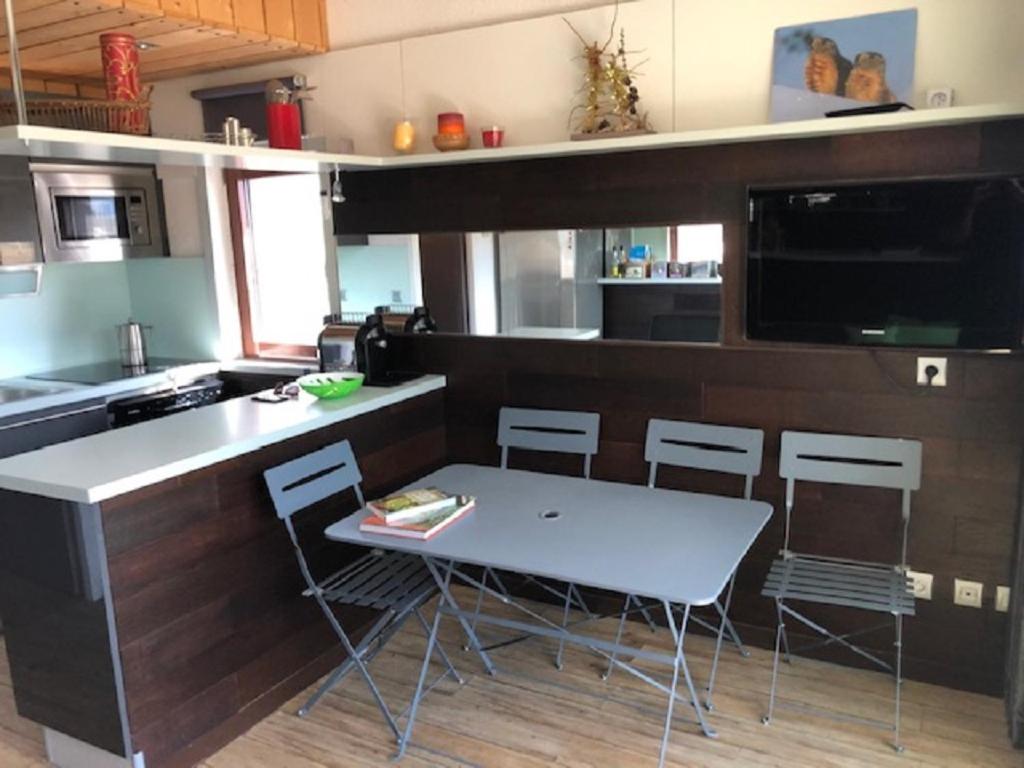 une cuisine avec une table et des chaises dans une cuisine dans l'établissement App 6places Ski Rando Pied des pistes soleil Alpes du sud, à Saint-Étienne-en-Dévoluy