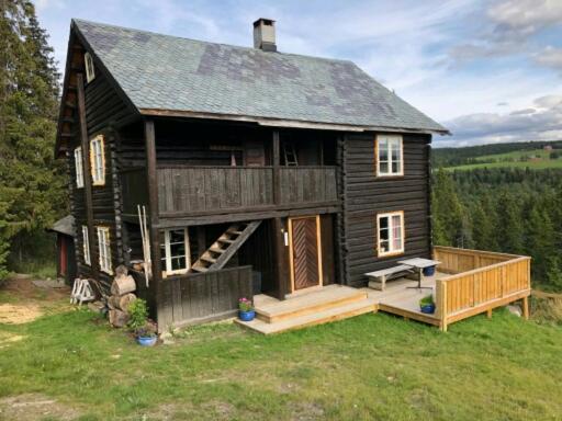 Cette grande maison en bois dispose d'une véranda et d'une terrasse. dans l'établissement Nedre Skogtun cabin by Norgesbooking, à Hovda