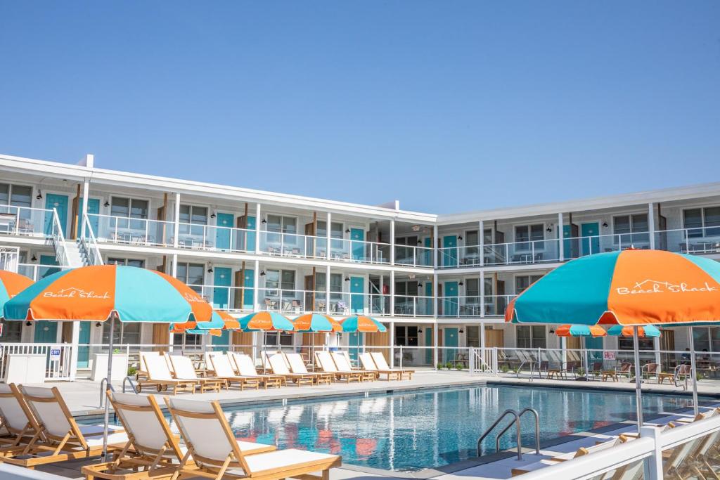 una piscina de hotel con sillas y sombrillas en Beach Shack, en Cape May