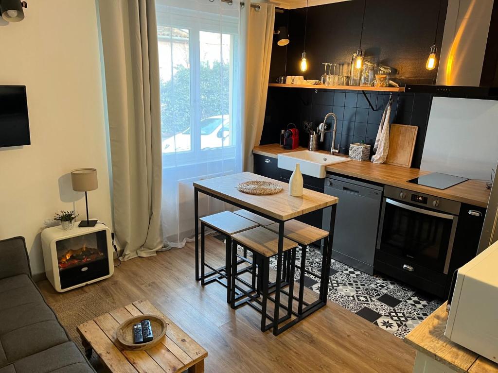 une petite cuisine avec une table et une cuisinière dans l'établissement Appartement cosy avec jardin quartier calme, à Toulouse