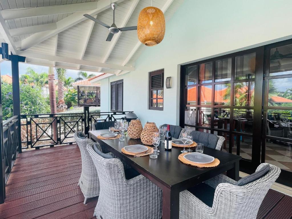 uma sala de jantar com uma mesa preta e cadeiras em Tip! Blue Bay Beachvilla 12 - Blue Bay Resort em Dorp Sint Michiel