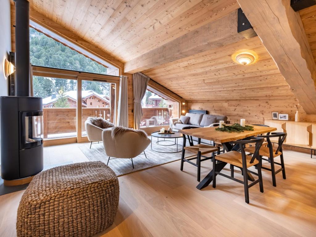 uma sala de estar com um tecto de madeira e uma mesa e cadeiras em Appartement Les Allues-Méribel, 3 pièces, 6 personnes - FR-1-355-213 em Les Allues