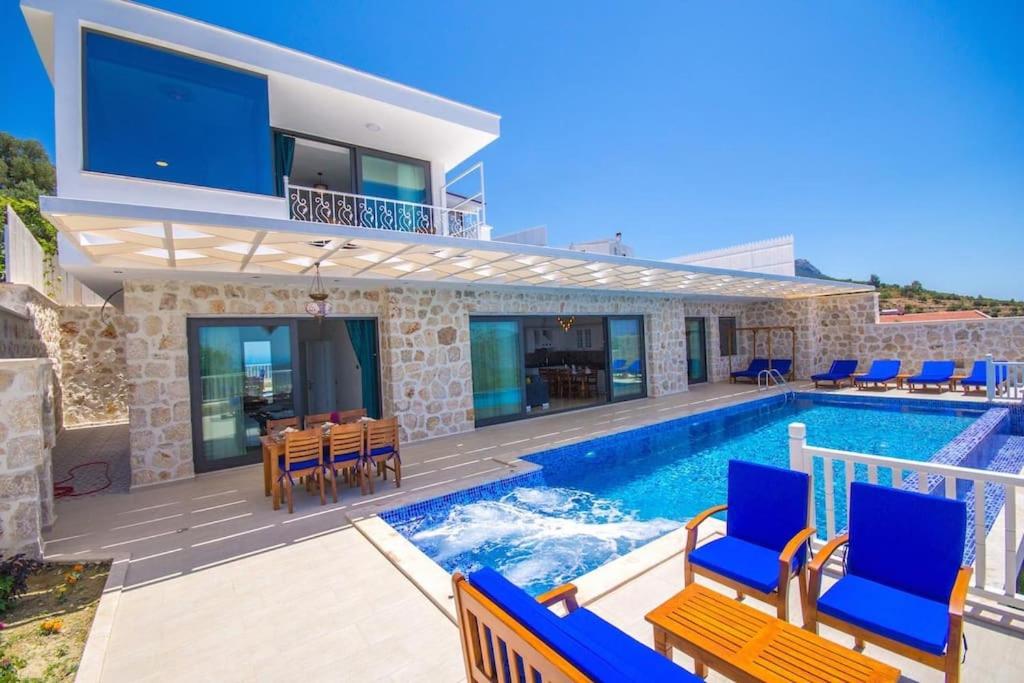 Villa mit einem Pool und blauen Stühlen in der Unterkunft Villa Karmen in Kaş
