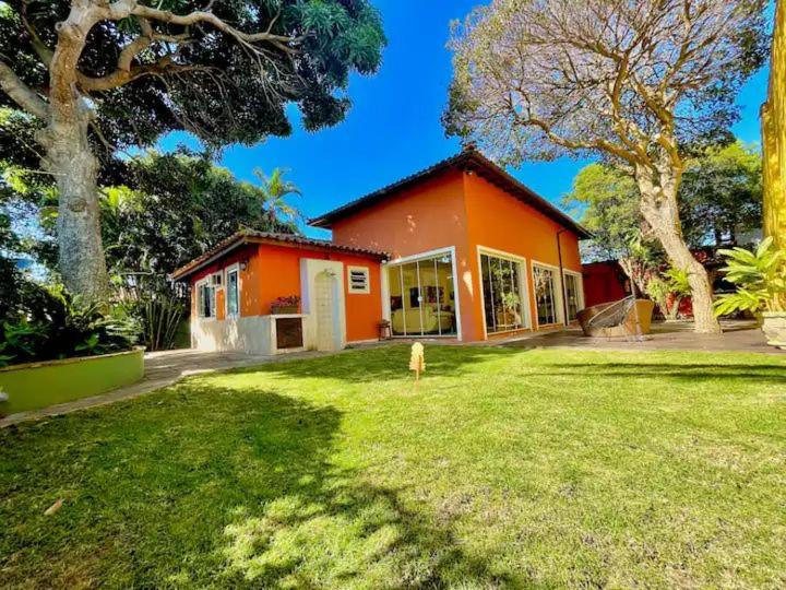 uma casa laranja com um quintal em frente em ossos paradise em Búzios
