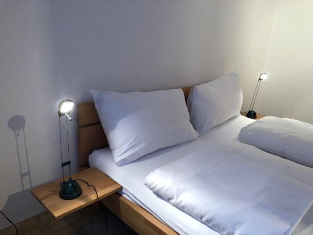 ein Bett mit zwei Kissen und zwei Lampen auf dem Tisch in der Unterkunft Komfortabel, Perfekte Lage, neue Wohnung, gratis P in Lauterbrunnen