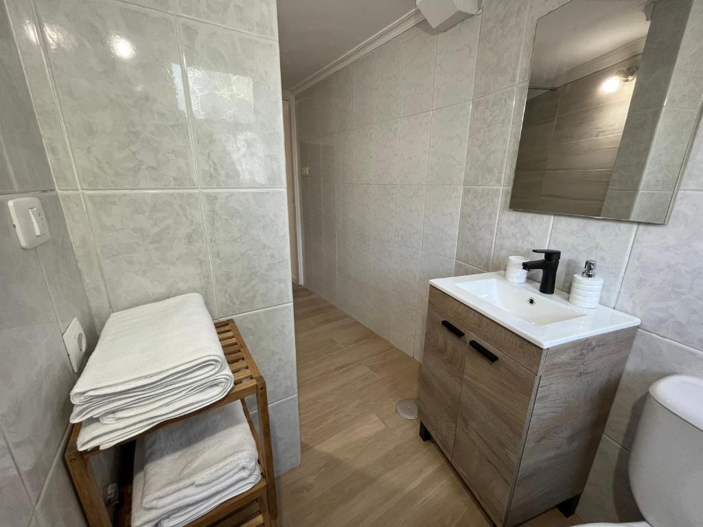a bathroom with a sink and a toilet and a mirror at Apartamento playa Vigo in Vigo