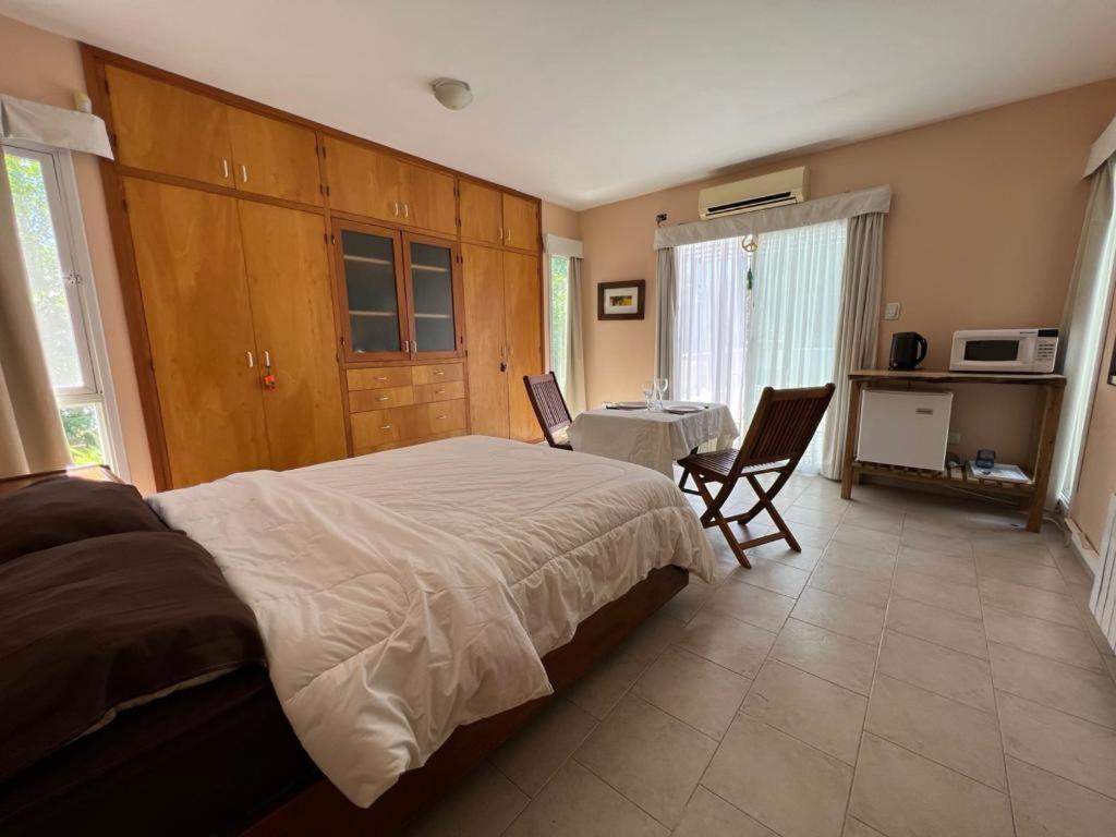 Un dormitorio con una cama grande y una mesa. en Terracita Suite en Villa Cura Brochero