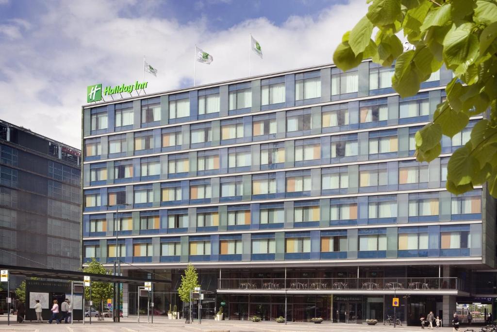 a large building with a sign on top of it at Holiday Inn Helsinki City Centre, an IHG Hotel in Helsinki