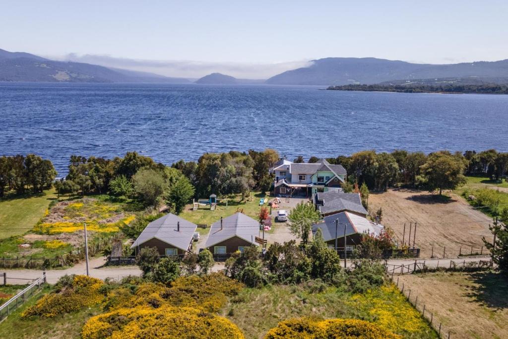 an aerial view of a house on the shore of a lake at Cabañas Torre Huillinco in Huillinco