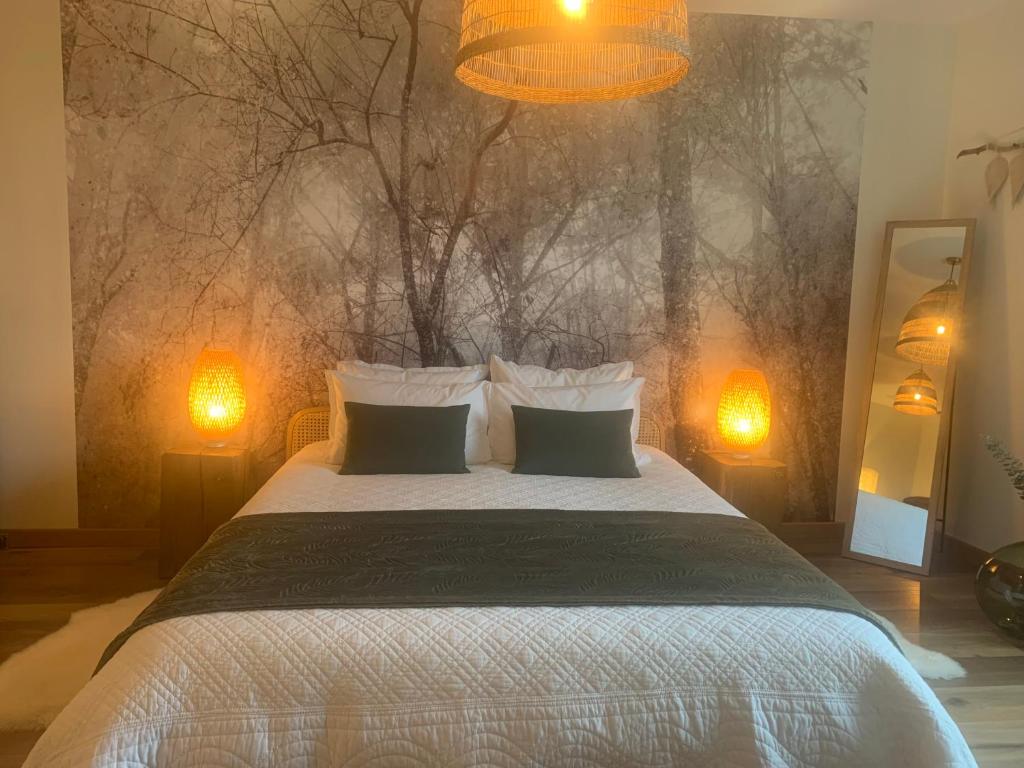 ein Schlafzimmer mit einem großen Bett mit zwei Leuchten in der Unterkunft Maison Mard'Or Chambre Sylvaé in Mardor