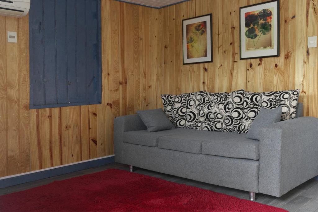 - un salon avec un canapé et un tapis rouge dans l'établissement Casa Charlie, à Areguá