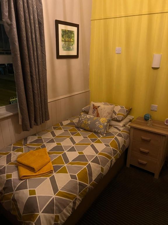 een kleine slaapkamer met een bed en een tafel bij The Fox Inn in Abingdon