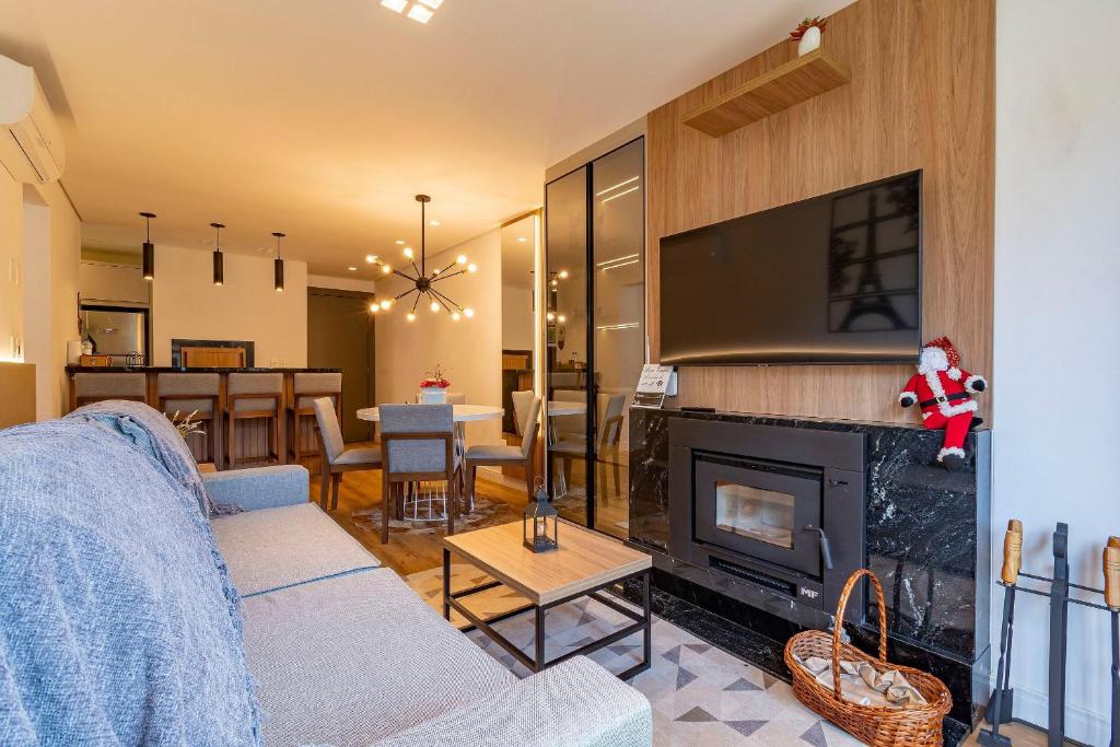 ein Wohnzimmer mit Couch und Kamin in der Unterkunft Rosa Edifício Bav in Gramado