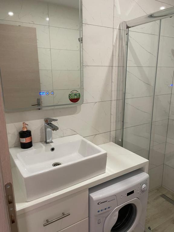 łazienka z umywalką i pralką w obiekcie Neraida Central Apartment w mieście Lutraki