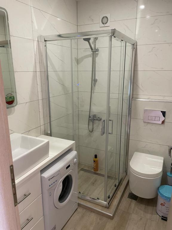 łazienka z prysznicem i pralką w obiekcie Neraida Central Apartment w mieście Lutraki