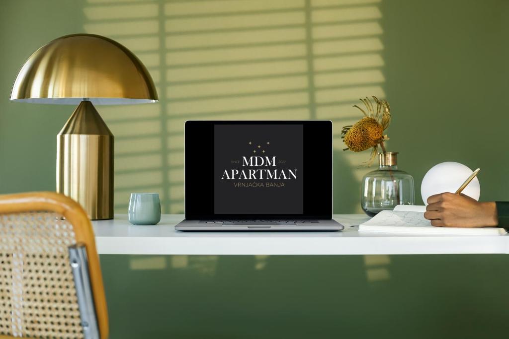 a laptop computer sitting on a desk with a lamp at MDM Apartman Vrnjačka Banja in Vrnjačka Banja