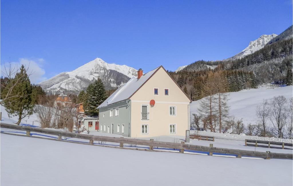 une maison blanche dans la neige avec des montagnes en arrière-plan dans l'établissement Gorgeous Apartment In Vodernberg With House A Mountain View, à Vordernberg