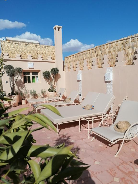 un patio avec des chaises et des tables dans un bâtiment dans l'établissement DAR MAR'OUKA , Maison d'hôtes, à Marrakech