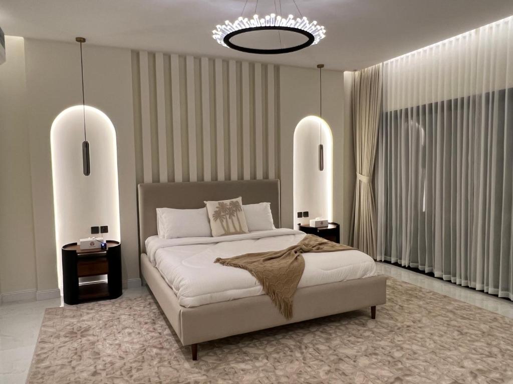 a bedroom with a large bed and a chandelier at Quiet House villa in Hatta