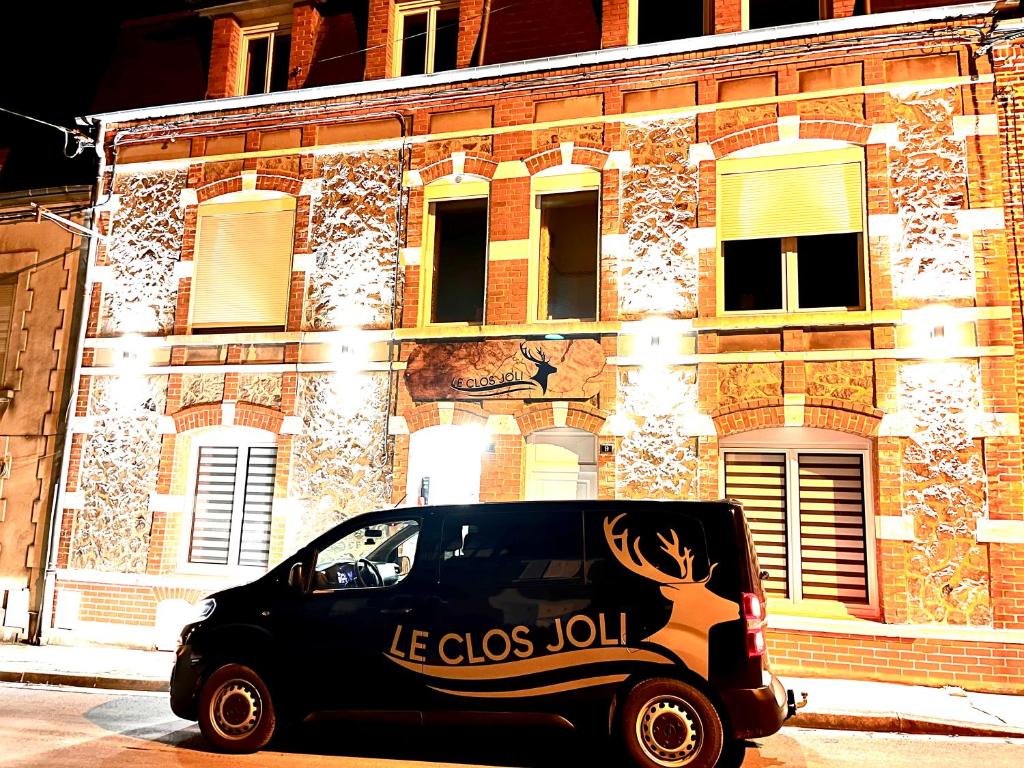 Le Clos Joli في Haybes: سيارة سوداء متوقفة أمام مبنى