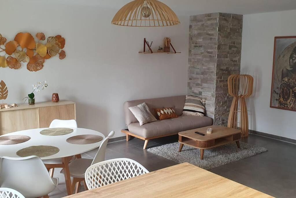 sala de estar con sofá y mesa en Logement entier de plain-pied en Épagny