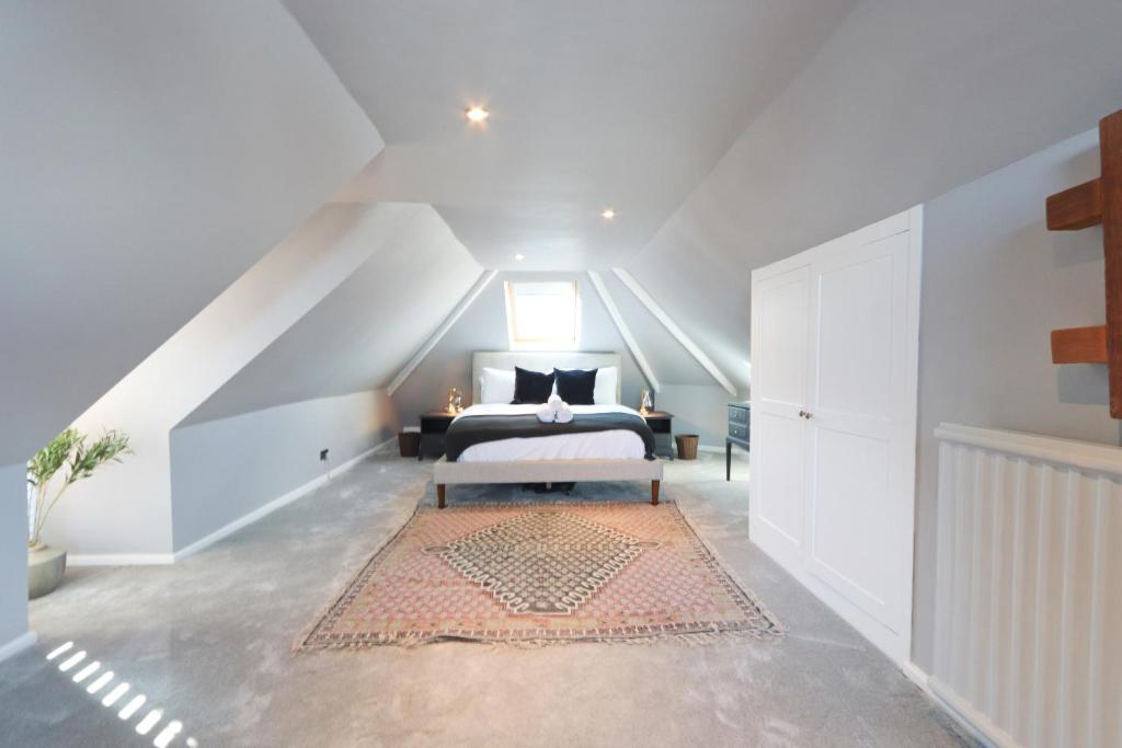 sypialnia na poddaszu z łóżkiem i dywanem w obiekcie Terracotta House w Bristolu