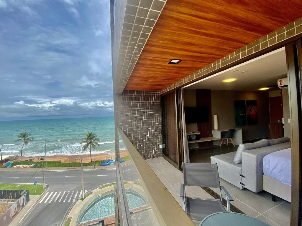 1 dormitorio con vistas al océano desde el balcón en Edifício Loft Apto 502 ER Hospedagens, en Maceió