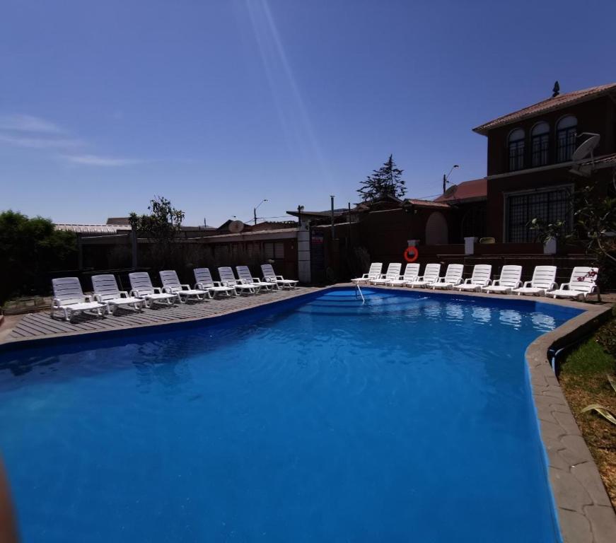 a large swimming pool with lounge chairs at Hotel Huasco in Huasco