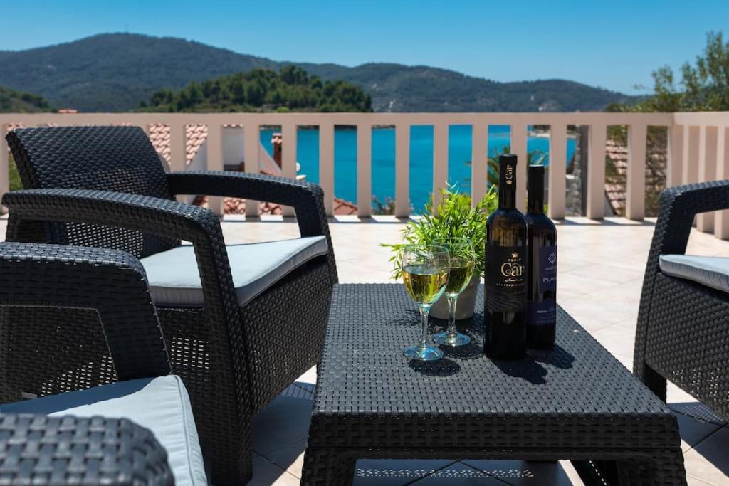een fles wijn en twee glazen op een tafel bij kuća za odmor Iris in Vela Luka