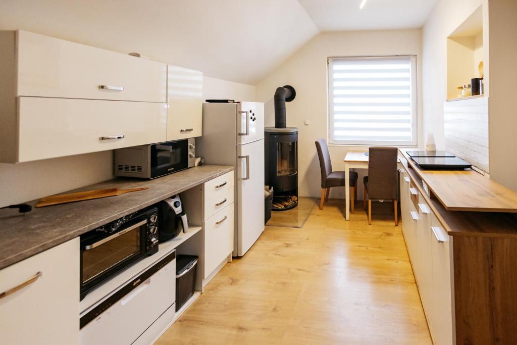 uma cozinha com armários brancos e piso em madeira em Mojstranka em Mojstrana