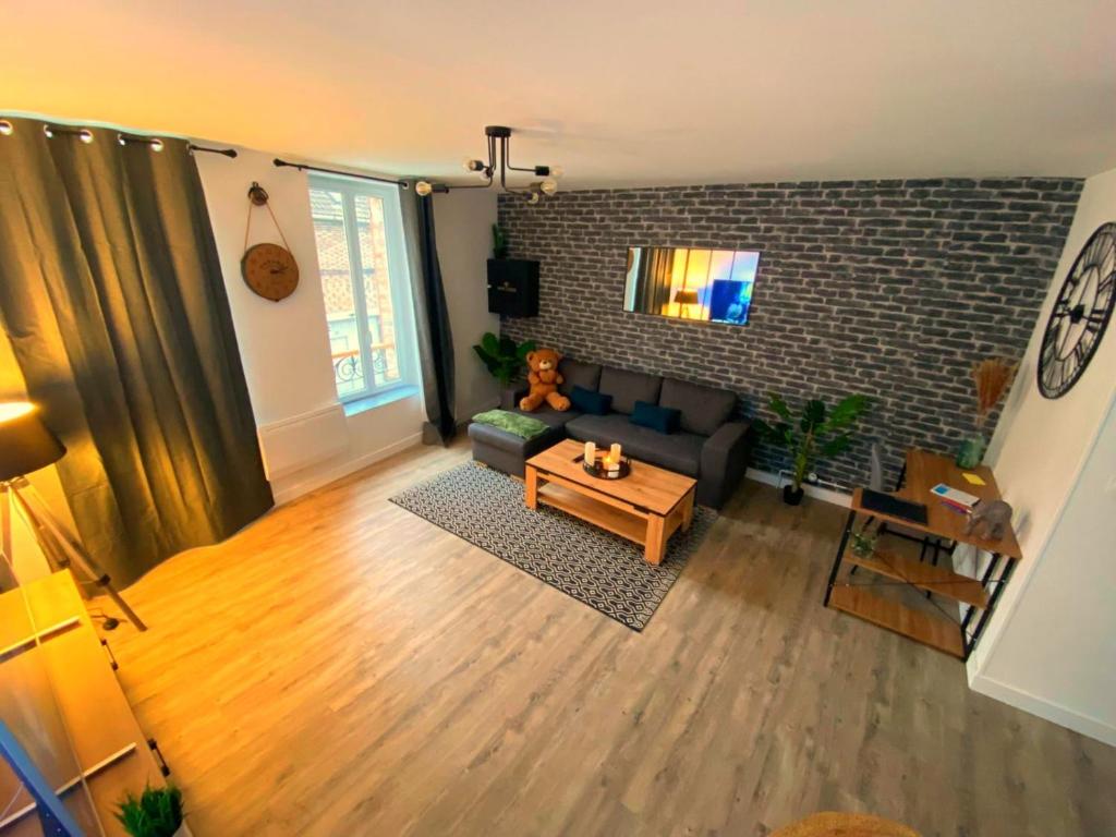 een woonkamer met een bank en een tafel bij Super Appartement T3 proche gare in Sens