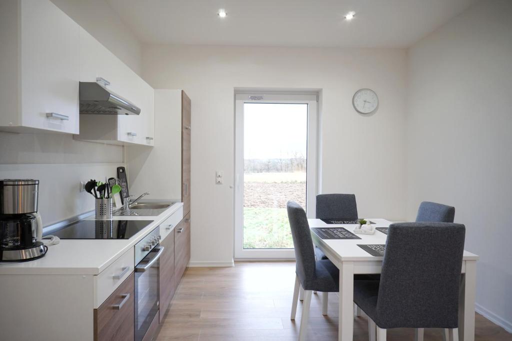 a white kitchen with a table and chairs and a counter at Kelbergerly Hills in Kelberg