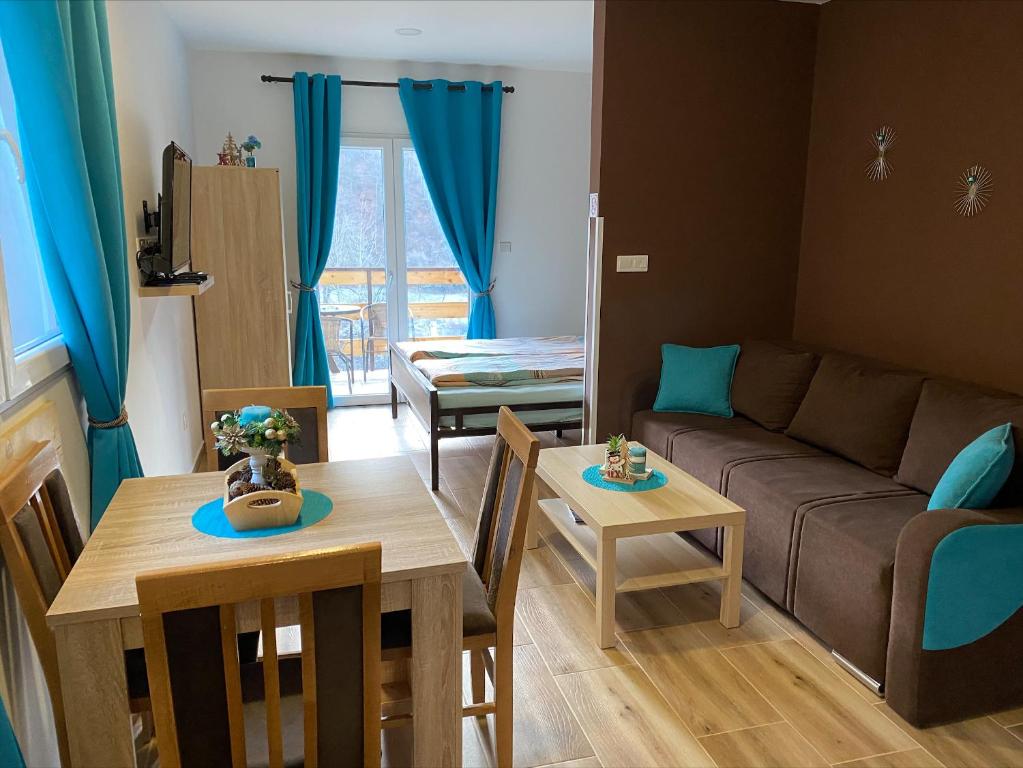 - un salon avec un canapé et une table dans l'établissement Blue Lagoon Apartments, à Crni Vrh