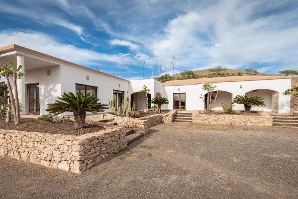a large white house with a stone wall at Casa El Kornao, Fuerteventura in Tuineje