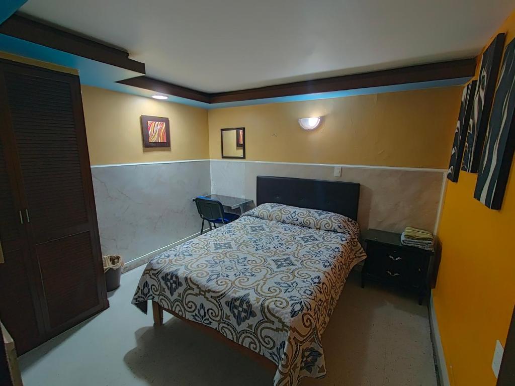 a small bedroom with a bed and a door at Casa Azul Aragon in Mexico City
