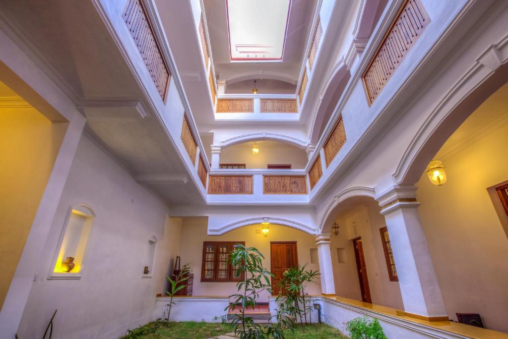 a large hall with ceilings and plants in a building at The Fort Bungalow in Cochin