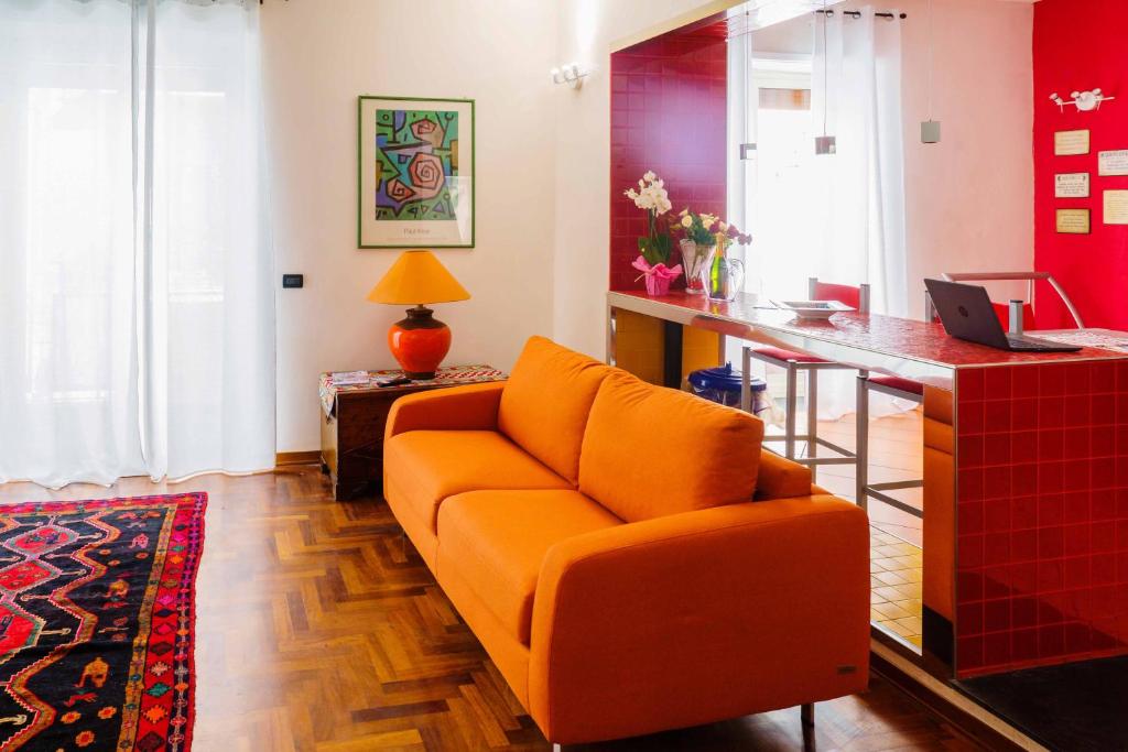 カターニアにあるAmoCatania Apartmentのリビングルーム(オレンジ色のソファ、デスク付)