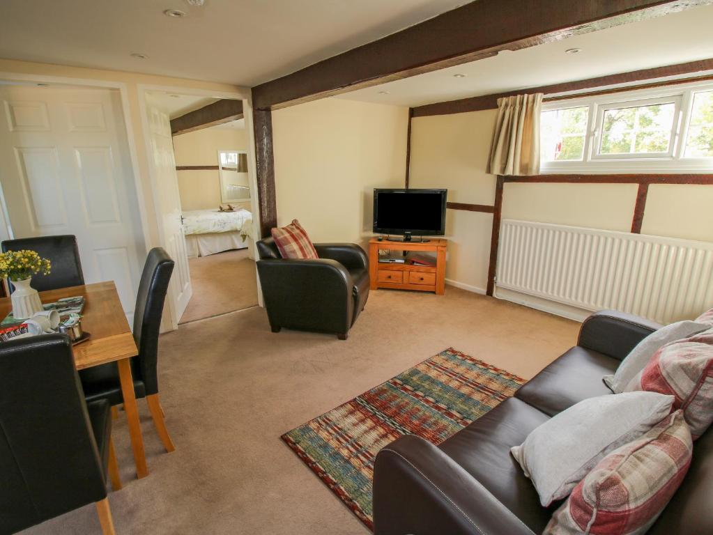 a living room with a couch and a tv at The Grain Store in Nantwich