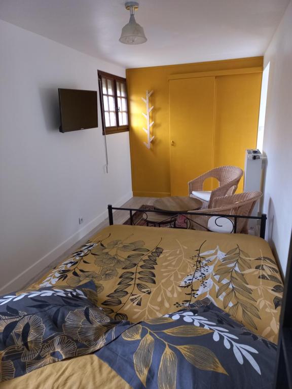 布朗托姆的住宿－Au Dolmen，一间卧室设有一张床和一个黄色的门