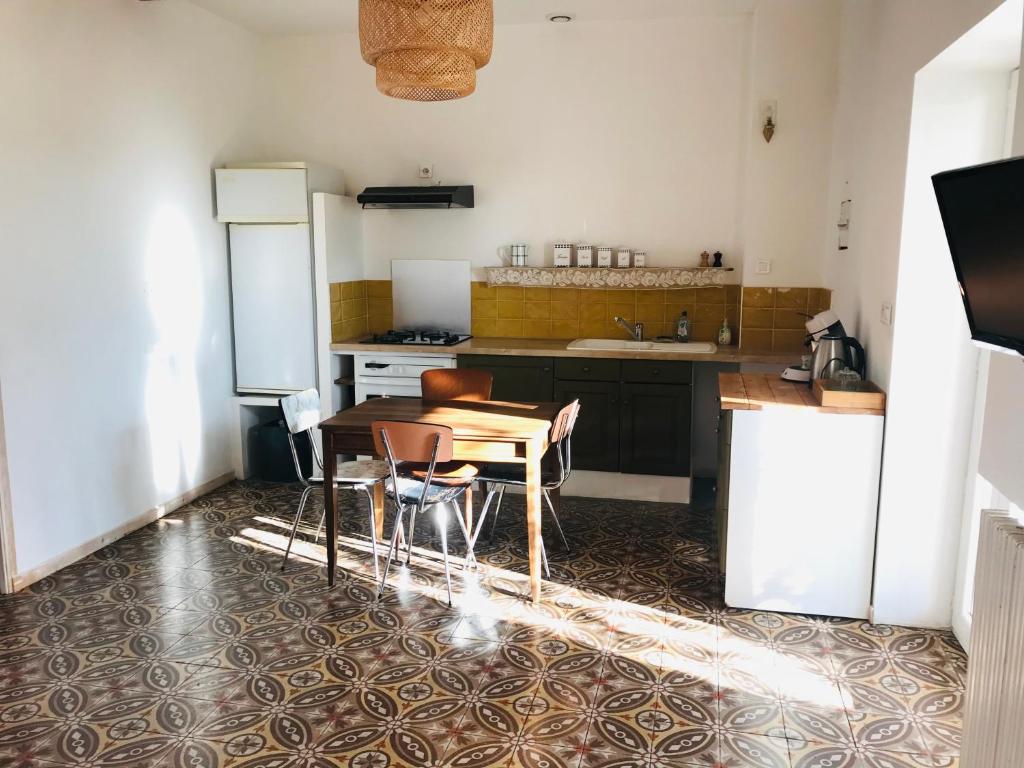 une cuisine avec une table et des chaises dans l'établissement Gîte de la Bastide, à Autignac