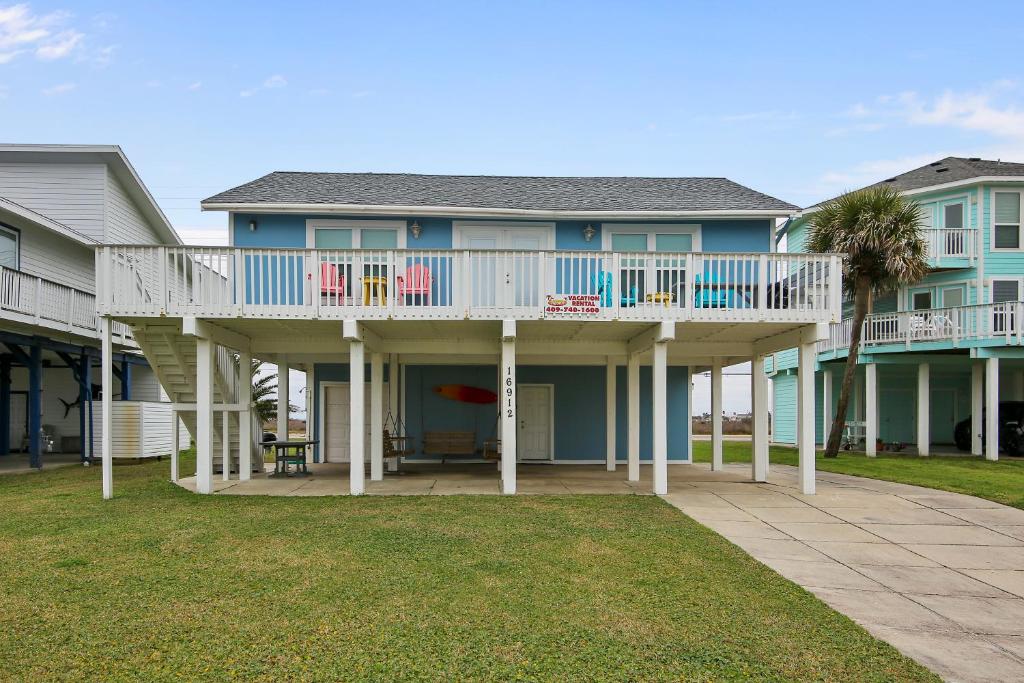 a large house with a deck and a patio at Barefoot Bungalow in Galveston