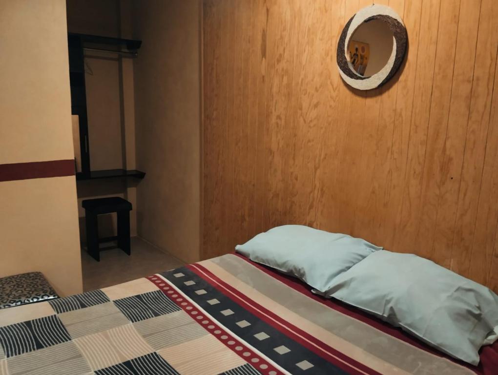 um quarto com uma cama e um espelho na parede em Hotel Nikko em Chignahuapan
