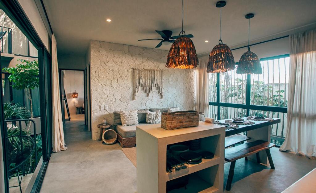 a living room with two pendant lights and a couch at Vida Jungle Apart 7 with special fee to access Hotel Bardo in Tulum