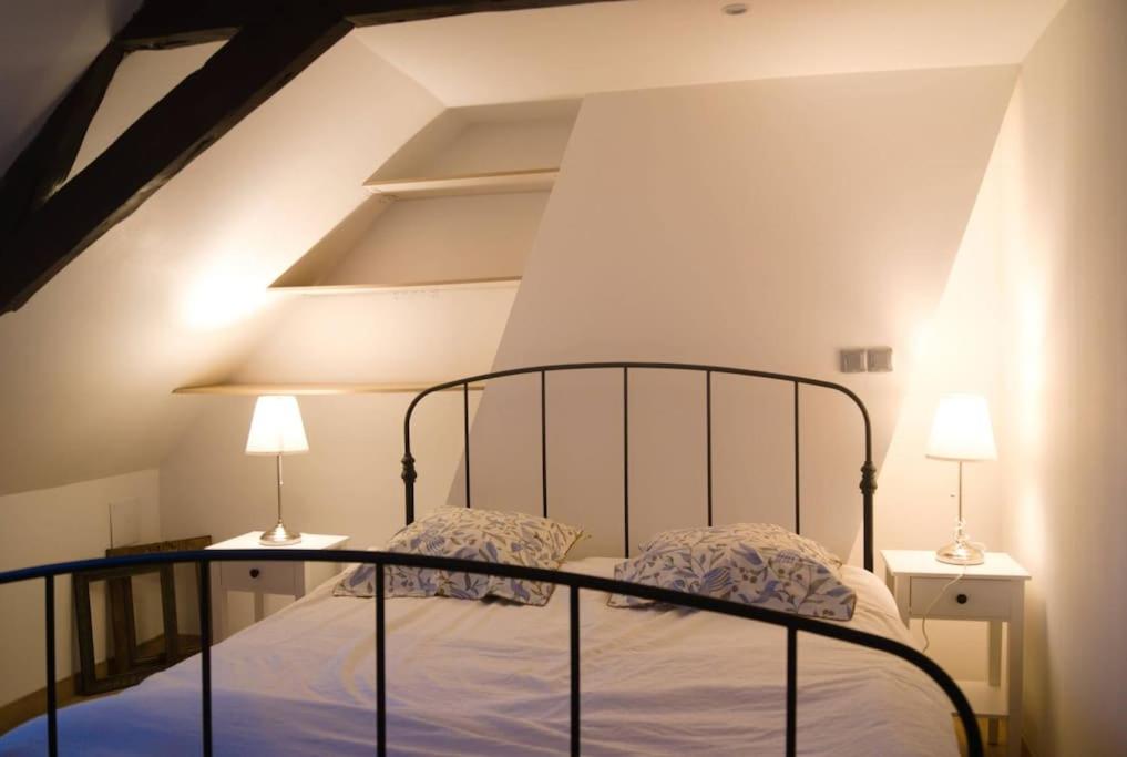 een slaapkamer met een bed met twee lampen erop bij maison R&vâmes in Calais