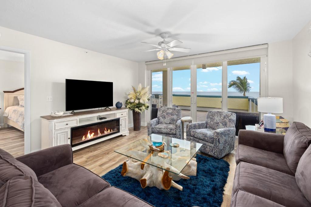 a living room with a couch and chairs and a fireplace at Apollo #210 in Marco Island