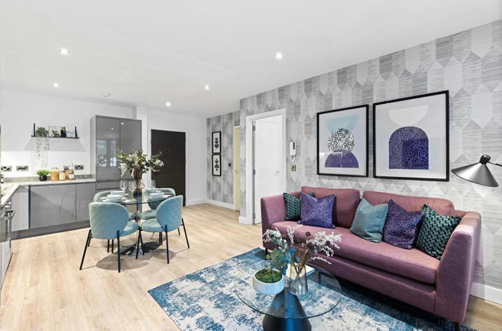 a living room with a purple couch and a table at Luxury Modern, One bedroom flat in Solihull