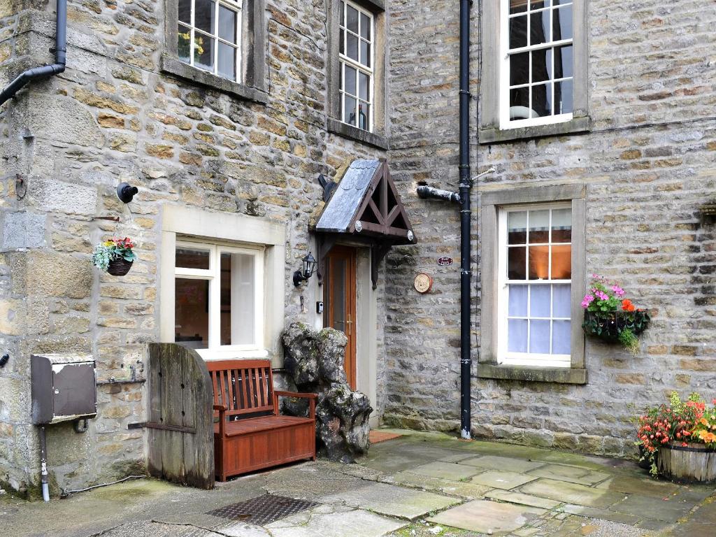 a stone building with a bench in front of it at Old Milverton in Grassington