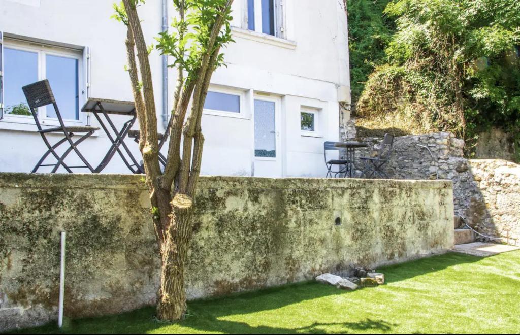 uma parede com uma árvore em frente a uma casa em Les Logis Poitevin - Maisons - Terrasses - Détente em Poitiers