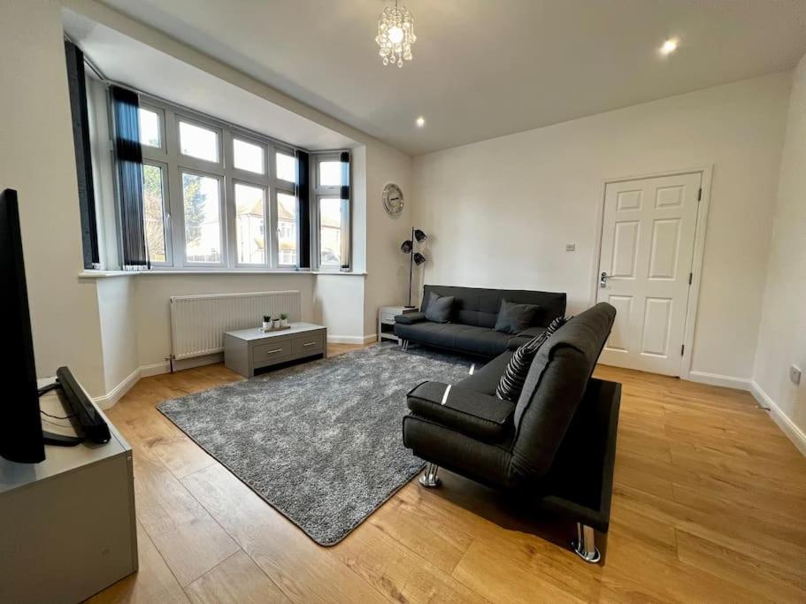 a living room with a black leather couch and a rug at Luxury Apartment in Nuneaton in Nuneaton